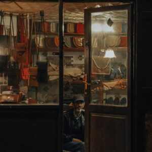 An Elderly Man Sitting in a Store with Handmade Leather Bags