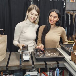 Girlfriends paying with smartphone for purchases